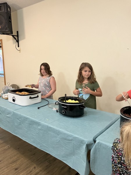 Two girls serving hot food